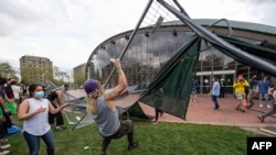 Pro-Palestinian supporters tear down the wall as they retake the encampment at the Massachusetts Institute of Technology in Cambridge, Massachusetts, on May 6, 2024. 