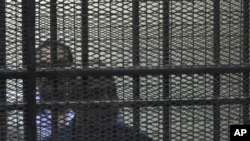 Egypt's former Interior Minister Habib al-Adly, front, stands behind bars during his trial on charges relating to the killing of nearly 900 protesters during the 18-day uprising, Cairo, Egypt, July 25, 2011