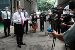 FILE - U.S. Health and Human Services Secretary Alex Azar, 2nd from left, answers to the media after visiting a mask factory in New Taipei City, Taiwan, Aug. 12, 2020.