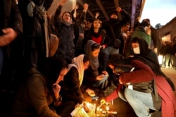 People gather for a candlelight vigil to remember the victims of the Ukraine plane crash, at the gate of Amrikabir University that some of the victims of the crash were former students of, in Tehran, Iran, Jan. 11, 2020.