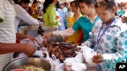 FILE - Cambodian Garment workers buy some cheap food for their lunch in front of the factory in downtown of Phnom Penh, Cambodia, March 10, 2011. 