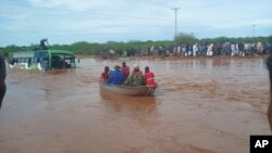Passengers of a bus that was swept away by floodwaters are rescued by boat, near Garissa, Kenya, on April 9, 2024.