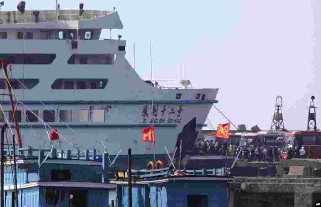 While riot police stand by, workers board a Chinese ship at Vung Ang port, Ha Tinh province, Vietnam, May 19, 2014.&nbsp;