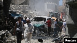People inspect the damage at a site hit by a barrel bomb in the rebel held area of Old Aleppo, Syria, July 11, 2016. 