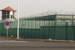 FILE - A guard tower and barbed wire fence surround a detention facility in the Kunshan Industrial Park in Artux in western China's Xinjiang region, Dec. 3, 2018.
