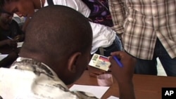 A Haitian worker at the US military's data collection center in Port-au-Prince checks identification from people needing help.