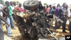 Warga mengerumuni rongsokan mobil yang meledak di lokasi gereja di Yelwa, Bauchi, pada awal bulamn Juni (foto: dok)