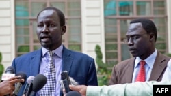 FILE - Lul Ruai Koang (L), the military spokesperson for the Sudan People's Liberation Army (SPLA) and James Gatdet Dak, spokesperson for opposition leader Riek Machar (R), give a statement to the press in Addis Ababa on May 9, 2014. 