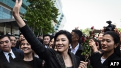 FILE - Former Thai prime minister Yingluck Shinawatra waves to supporters as she leaves the Supreme Court in Bangkok on Aug. 1, 2017. Thailand's Supreme Court on Monday cleared her of corruption in awarding a government contract during her time in office. 