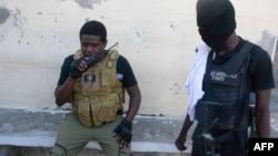 Gang leader Jimmy "Barbecue" Cherizier speaks into his walkie talkie before a mission, in Port-au-Prince, Haiti, March 5, 2024. Cherizier presents himself as a revolutionary, and says he wants to sweep away the crisis-torn country's elite.