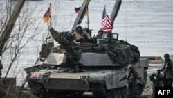 资料照片: 2024年3月4日美国和德国军人参加在波兰北部科尔泽涅沃举行的北约DRAGON-24军事演习。