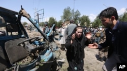 FILE - An Afghan woman cries out at the site of a suicide attack on a NATO convoy in Kabul, Afghanistan, June 30, 2015.