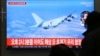 People watch a TV screen showing file footage of a Japanese patrol plane during a news program at the Seoul Railway Station in Seoul, South Korea, Jan. 23, 2019. 