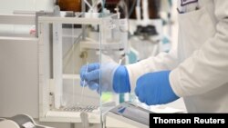 FILE - A chemist works at AstraZeneca's headquarters, in Sydney, Australia. AstraZeneca has a deal with Australia to produce and distribute a vaccine being developed by Britain's Oxford University.