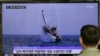 A South Korean man watches a TV news program showing an image published in North Korea's Rodong Sinmun newspaper of North Korea's ballistic missile believed to have been launched from underwater, at Seoul Railway station in Seoul, South Korea, Saturday, M