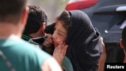A man carries an injured girl after airstrikes on the rebel-held al-Qaterji neighborhood of Aleppo, Syria, Sept. 21, 2016.