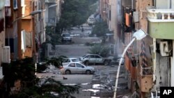 FILE - Damages are seen due to clashes between the Libyan military and Islamic militias in Benghazi, Libya. Representatives of Libya's rival factions who are sitting in Tunis and negotiating through a U.N.-brokered process announced on Tuesday that they have formed a unity government aimed at stemming the chaos that has engulfed the country for the past years.