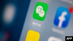 FILE - This illustration picture taken on July 24, 2019 in Paris shows the logo of the Chinese instant messaging application WeChat on the screen of a tablet.