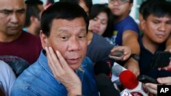 FILE - Philippine presidential candidate Rodrigo Duterte talks to the media before boarding his flight for his hometown of Davao city in southern Philippines.