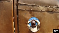 FILE - A five-year-old HIV-positive boy stands in the courtyard of the preschool he attends in Kibera, the largest slum in Kenya, Nov. 29, 2010. 