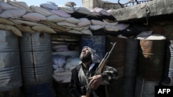 A Syrian rebel fighter from the Failaq al-Rahman brigade mans a position on the frontline against regime forces in the town of Arbin in the eastern Ghouta region on the outskirts of the capital Damascus on February 26, 2016.
