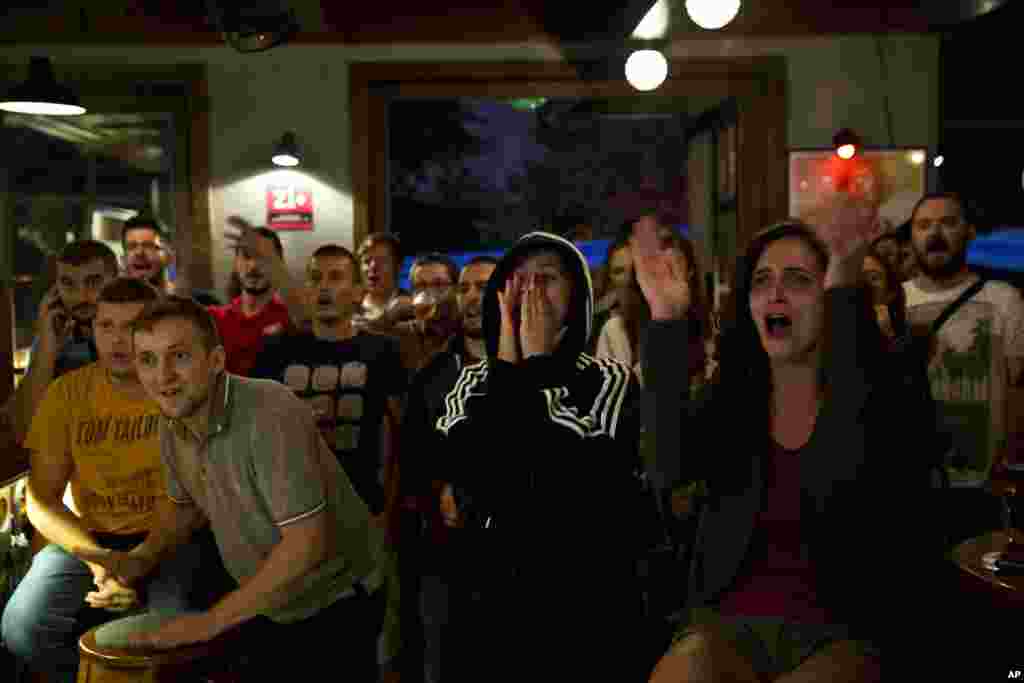 Para pendukung tim Kosovo merayakan medali emas yang didapat Majlinda Kelmendi di Pristina, Kosovo (7/8) saat melihat pertandingan yudo putri kelas 52 kilogram di Olimpiade Rio de Janeiro, Brazil, dari telavisi. (AP/Visar Kryeziu)