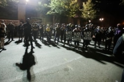 A crowd gathers during a Black Lives Matter protest at the Mark O. Hatfield United States Courthouse, July 30, 2020, in Portland, Ore. After days of clashes with federal police, the crowd outside of the federal courthouse remained peaceful.