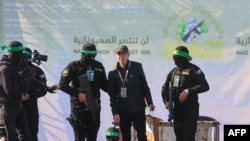 Các chiến binh Hamas dẫn con tin người Mỹ gốc Israel Keith Siegel lên sân khấu trước khi trao trả cho hội Chữ thập đỏ tại Thành phố Gaza vào ngày 1/2/2025.