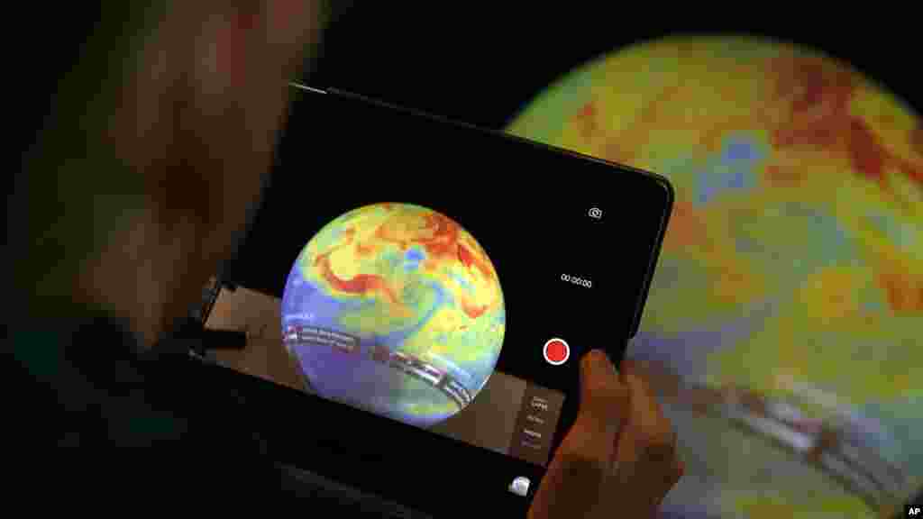 Une femme prend la photo d'un globe à la COP21, 7 décembre 2015 au Bourget, France.