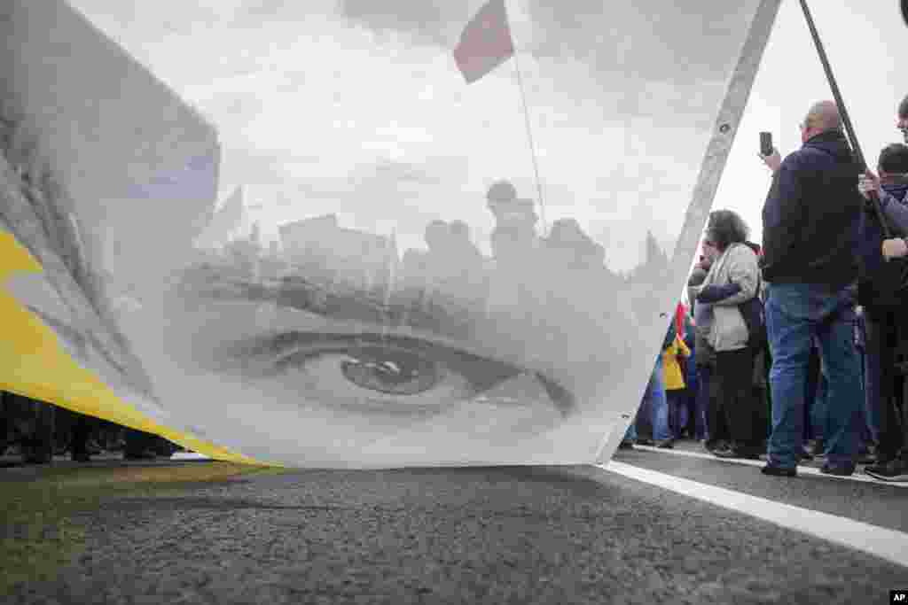 Protesters hold a poster with the image of political prisoner Oleg Sentsov during an opposition rally organized by &#39;Free Russia&#39; in Moscow, Russia.