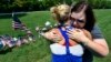 Sophia Ensley, left, comforts Barbie Branum by a makeshift memorial at the entrance to the Naval Operational Support Center and Marine Reserve Center in Chattanooga, Tennessee, July 18, 2015.
