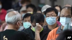 資料圖片：2022年11月26日星期六，在台灣新北市一投票站，當地居民在投票前被檢查體溫。 週六，台灣各地選民前往投票站參加備受關注的地方選舉。 在2024年總統大選之前，這次選舉將決定台灣主要政黨的實力。 （美聯社）