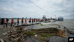 ARCHIVO - Migrantes venezolanos caminan hacia un barco que los llevará a Acandí, desde Necoclí, Colombia, el jueves 13 de octubre de 2022.