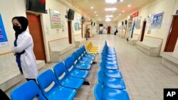 FILE - A nurse stands outside a coronavirus vaccination room at a clinic in Baghdad, Iraq, April 21, 2021. At least 23 people were reported killed in a fire April 24, 2021, at a coronavirus intensive care unit in Baghdad.
