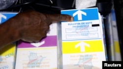 An agent of Congo's National Independent Electoral Commission points at ballots before voting starts at a poling station in Kinshasa, Democratic Republic of Congo, Dec. 30, 2018.
