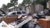 When the rains stopped in the Houston area for several hours Tuesday, residents pulled water-damaged carpets, furniture and other belongings out of their apartment buildings, leaving piles of debris outside their doors. (G. Flakus/VOA)