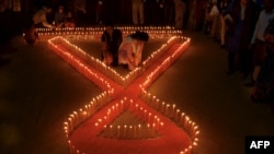 Indian NGO volunteers light candles in the shape of a ribbon during an awareness rally on the eve of World AIDS Day in Agartala, the capital of northeastern state of Tripura, Nov. 30, 2015.