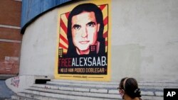 A woman walks near a poster asking for the freedom of Colombian businessman and Venezuelan special envoy Alex Saab, in Caracas, Venezuela, Oct. 16, 2021.