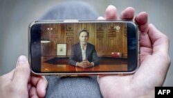 Промову прем'єр-міністра Нідерландів Марка Рютте дивляться зі смартфона. Фото: Robin Utrecht/ANP/AFP 