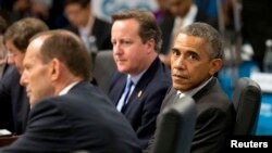 Presiden AS Barack Obama (kanan) duduk di samping Perdana Menteri Australia Tony Abbott (kiri) dan Perdana Menteri Inggris David Cameron dalam sebuah sidang di KTT pemimpin G20 di Brisbane, 15 November 2014.