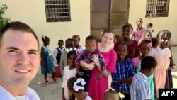 In this undated photo courtesy of Missions in Haiti, U.S. missionaries Davy and Natalie Lloyd pose with Haitian children. Gang members killed the couple in Port-au-Prince on May 23, 2024.