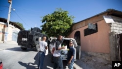 FILE - Izolan, center, Haitian rapper from the Barikad Crew band, stands with supporters of presidential candidate Jude Celestin after being briefly detained by police who searched their car, on the fringes of a protest against election results.