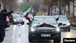 People ride in a car decorated with Syrian opposition flags, after Syrian rebels announced that they have ousted Syria's Bashar al-Assad, in Berlin, Germany, Dec. 8, 2024. 