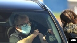FILE - A patient receives an injection of the Pfizer-BioNTech COVID-19 vaccine at a drive-in vaccination center in Hyde, Greater Manchester, northwest England, Dec. 17, 2020.