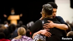 Mourners embrace during the funeral for Tony Robinson Jr. at Madison East High School in Madison, Wisconsin, March 14, 2015. 