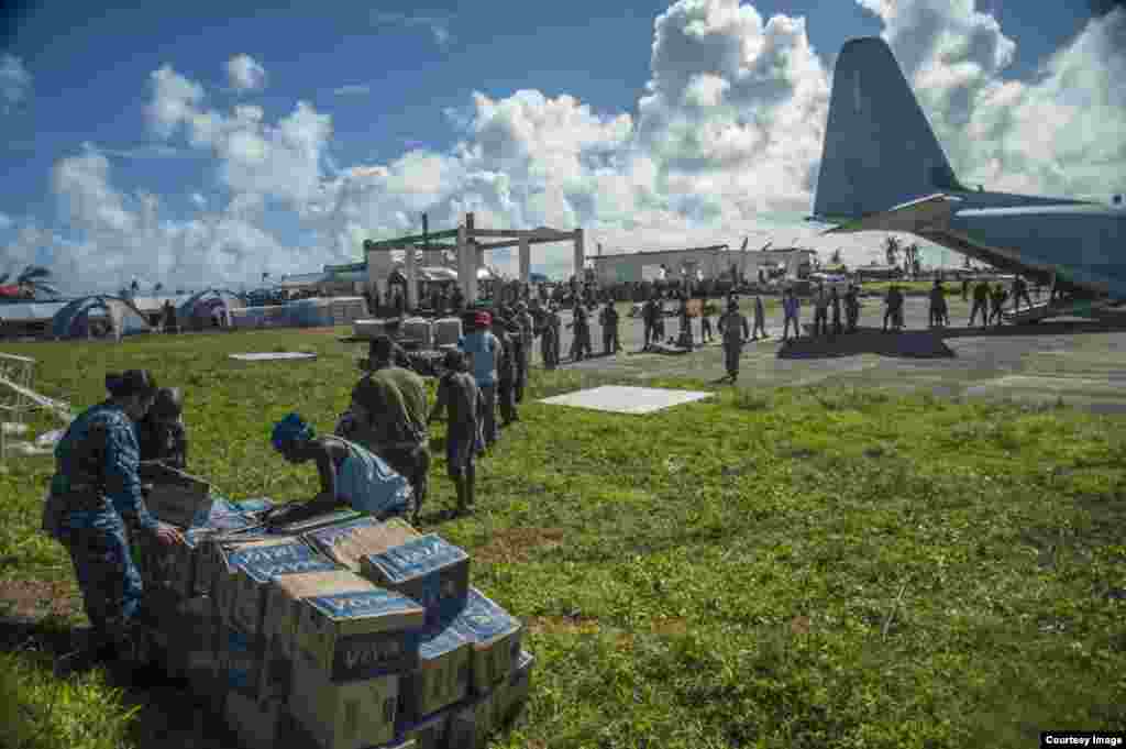 U.S. sailors and Marines work with Philippine civilians to unload relief supplies in Guiuan, Philippines, Nov. 17, 2013. (U.S. Navy)