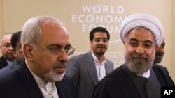 Presiden Iran Hassan Rouhani (kanan), dan Menlu Iran Mohammad Javad Zarif, menghadiri Forum Ekonomi Dunia di Davos, Swiss (22/1).