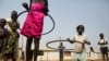 FILE - Children play with hula hoops at a UNICEF site in Juba, South Sudan, on Jan. 15, 2016. A new program to bring teenage mothers back to school is helping the country address the gender gap in education, experts say.