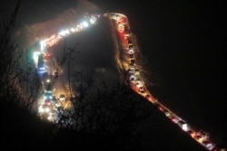 Cars and trucks stuck in a huge traffic jam climb along the road from Kalbajar to a mountain pass leaving the separatist region of Nagorno-Karabakh for Armenia, Nov. 14, 2020.