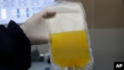 FILE - In this Friday, June 12, 2020 file photo, a doctor holds a bag of blood plasma donated by a COVID-19 survivor at at blood bank in La Paz, Bolivia.